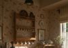 Warm, sunlit country kitchen scene with pancakes and tea set on a rustic table.