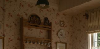 Warm, sunlit country kitchen scene with pancakes and tea set on a rustic table.