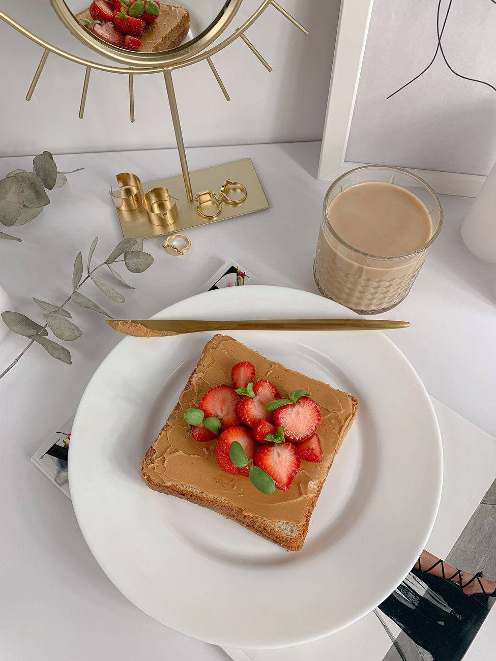Elegant breakfast setup with toast and strawberries on white plate.